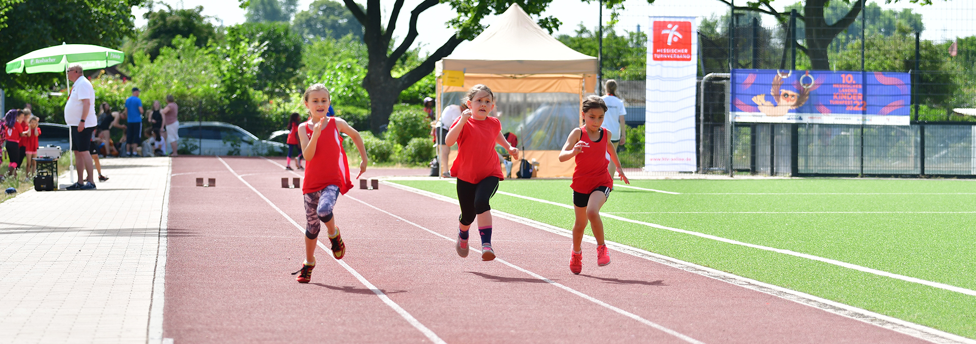 Kinder machen ein Wettrennen auf einem Sportplatz.