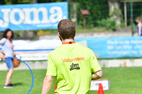 Ein Mann von hinten mit der T-Shirt Aufschrift "Volunteer".