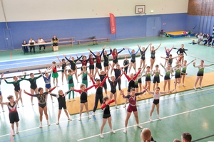 Junge Turner und Turnerinnen tanzen gemeinsam in einer Turnhalle den Turnfesttanz.