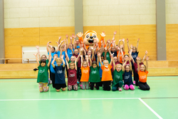 Ein Gruppenbild mit Kindern und dem Maskottchen der hessischen Turnjugend.