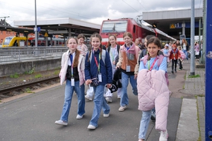 Kinder reisen am Bahnhof an. 