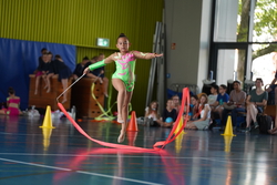Eine Gymnastin turnt eine Übung mit Band. 