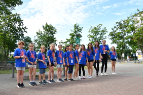 Mehrere Kinden stehen im Turnfest-T-Shirt in einer Reihe aufgestellt auf einem Schulhof.