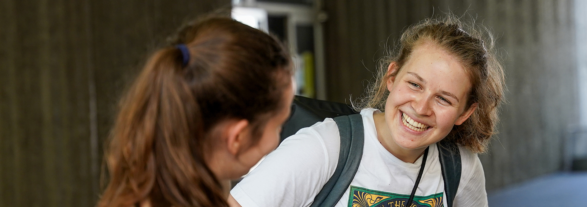 Eine junge Frau lächelt eine andere Frau an.