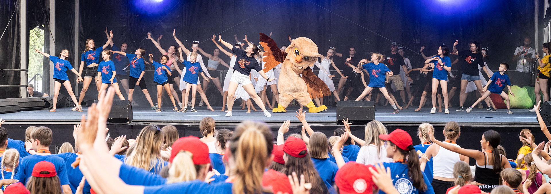 Eine Gruppe von Menschen tanzt auf und vor der Bühne.