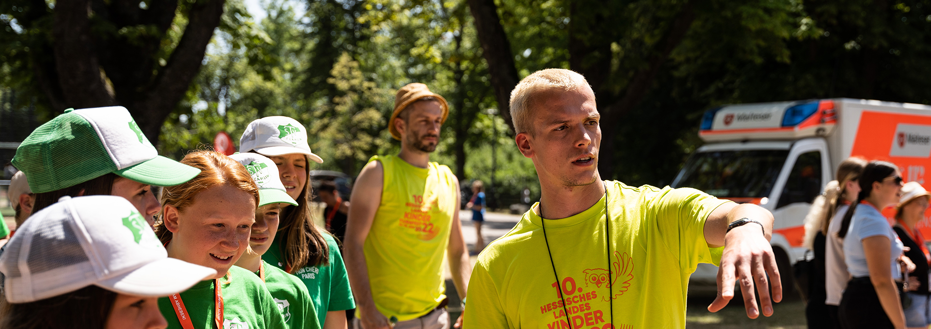 Ein junger Mann zeigt einer Gruppe, wo es langgeht.