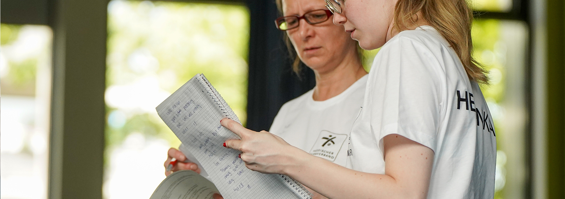 Zwei Frauen schauen sich ihre Notizen an.