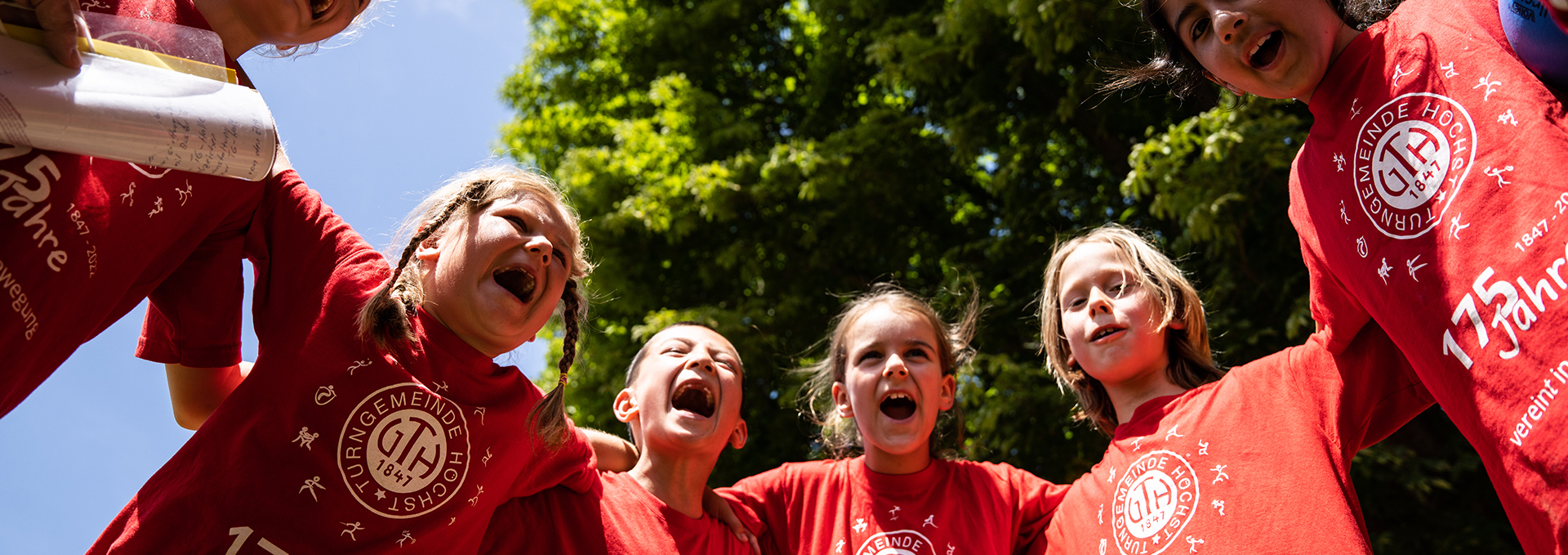 Eine Gruppe von Kindern umarmt sich und ruft gemeinsam einen Schlachtruf.
