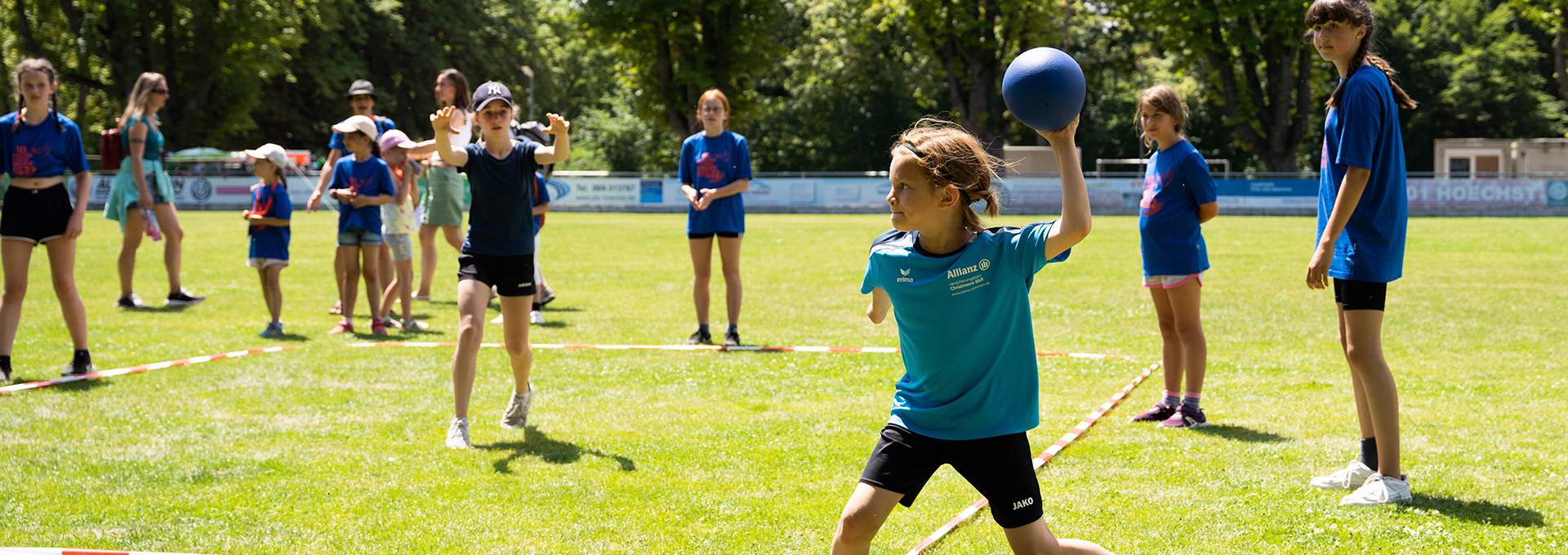 Mehrere Kinder spielen draußen Völkerball.