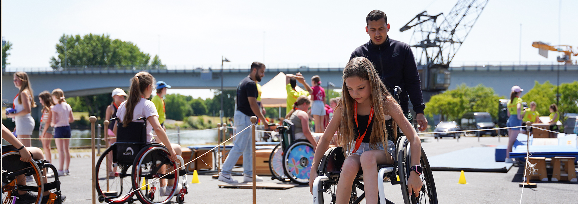 Ein Mädchen rollt mit einem Rollstuhl durch einen Parkour.
