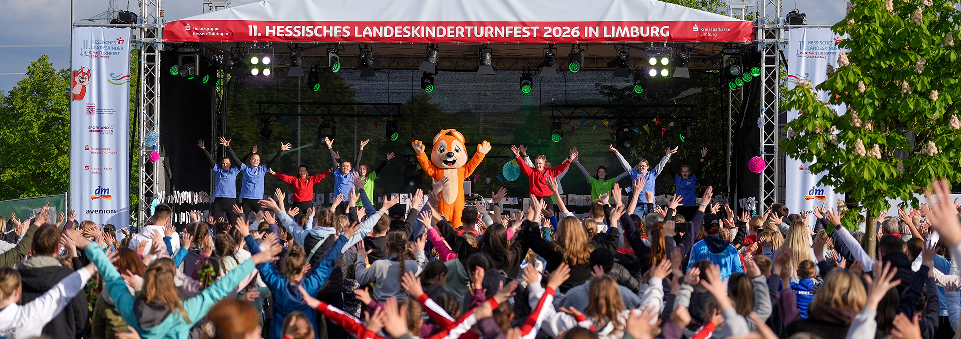 Auf und vor einer Bühne tanzen viele Menschen.
