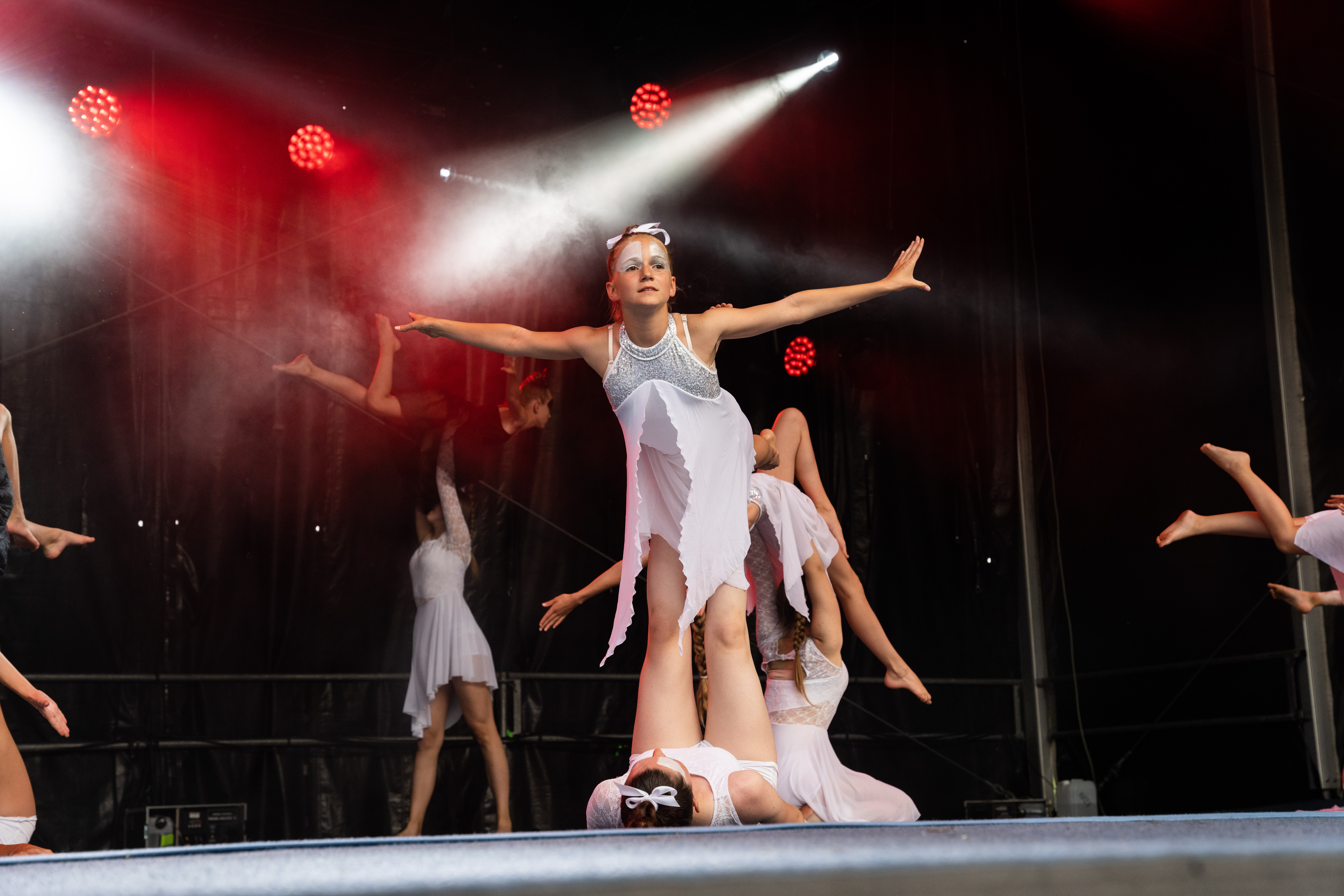 Eine Showgruppe zeigt eine Abschlusspose auf der Bühne.