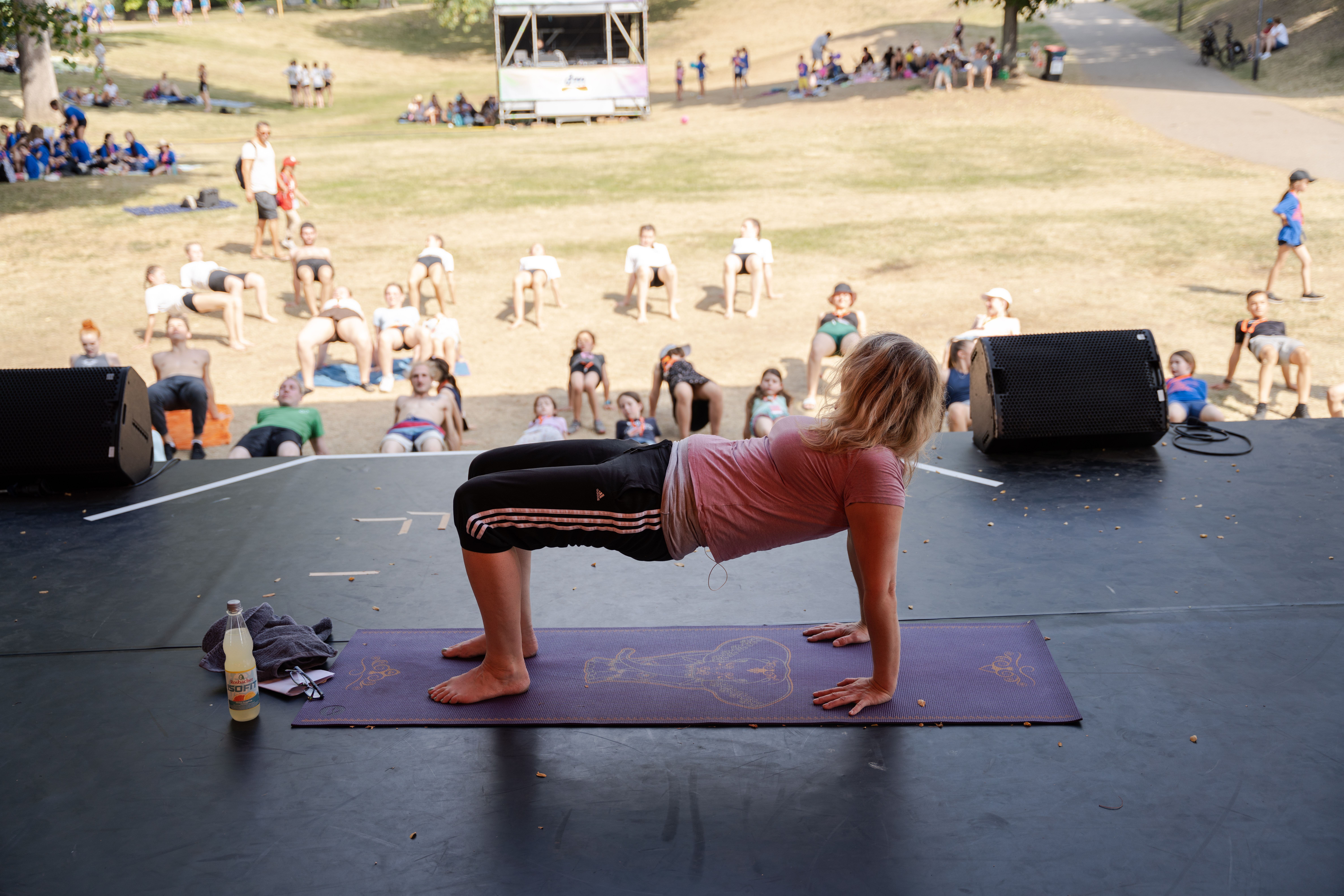 Eine Frau unterrichtet Yoga für mehrere Personen.